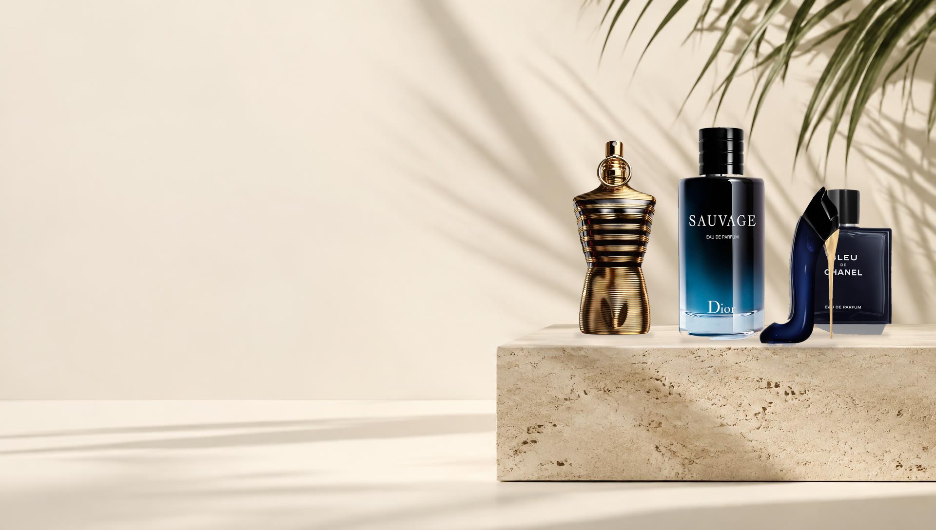 Perfumes Jean Paul Gaultier Le Male Elixir, Dior Sauvage Eau de Parfum, Bleu de Chanel Eau de Parfum e Carolina Herrera Good Girl sobre pedra travertino, com luz natural